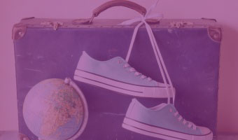 alter Koffer mit Turnschuhen und Globus