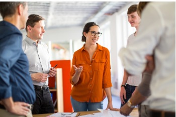 Mitarbeiter aus Kommunikationsabteilung stehen zusammen und unterhalten sich