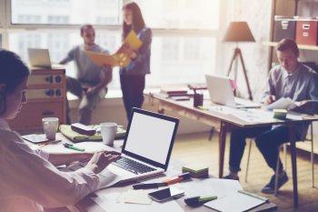 Mehrere Mitarbeiter an ihrem Arbeitsplatz im Büro