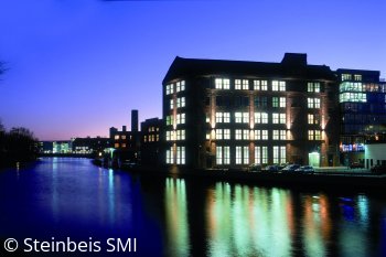 Außenansicht der Steinbeis SMI bei Nacht am Wasser